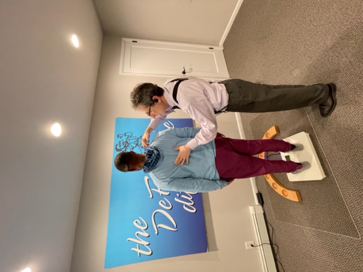 Dr. DeFabio reviewing posture and progress with a patient at the DeFabio Difference wall in Berkeley Heights, NJ