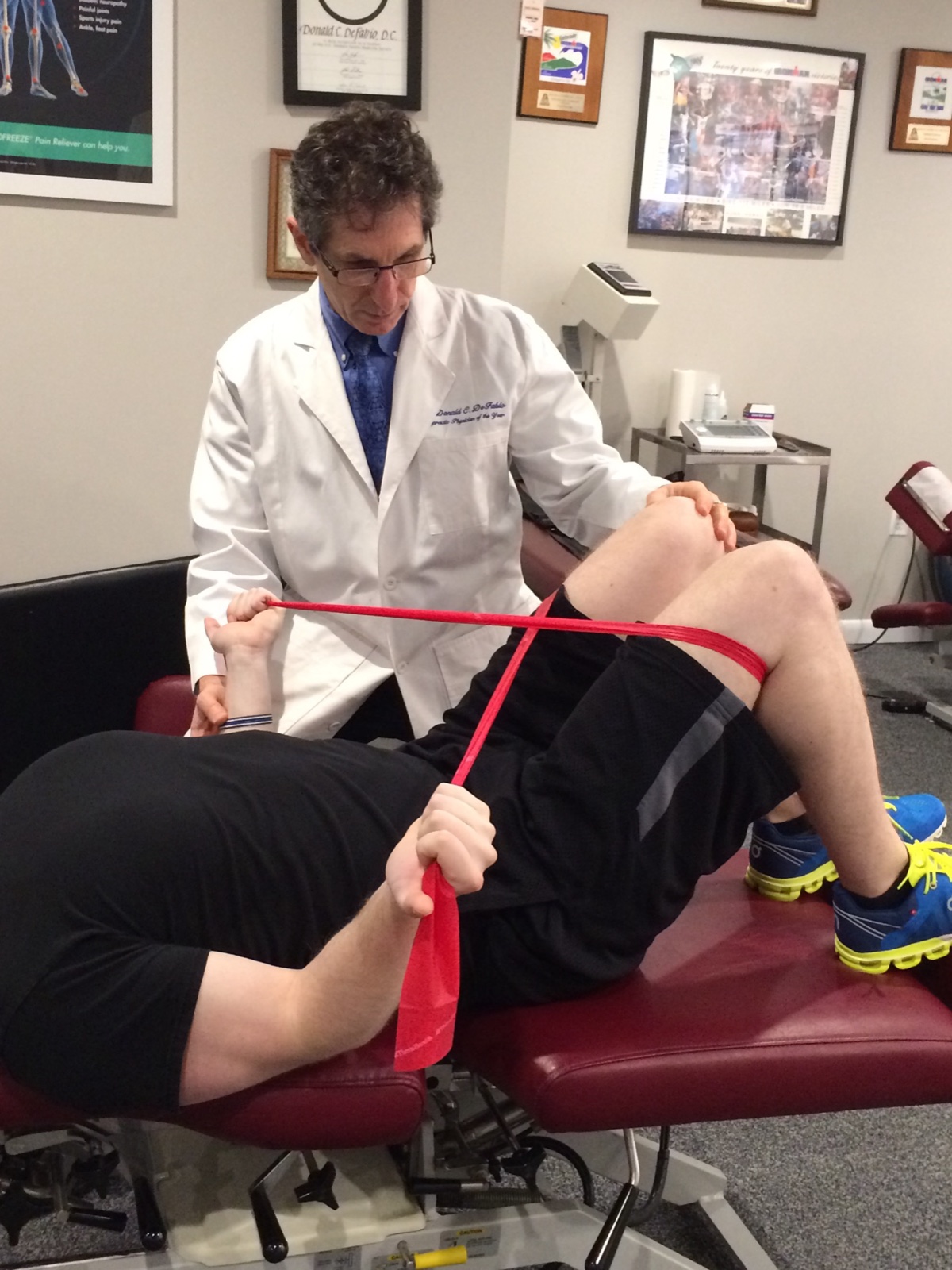 Guided physical rehabilitation exercise with a resistance band at DeFabio Chiropractic in Berkeley Heights, NJ